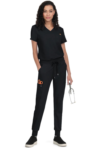 Women's Koi Cureology Aura C100 black tuck in scrub top - moisture-wicking v-neck medical scrub with functional pockets for nurses and healthcare professionals.