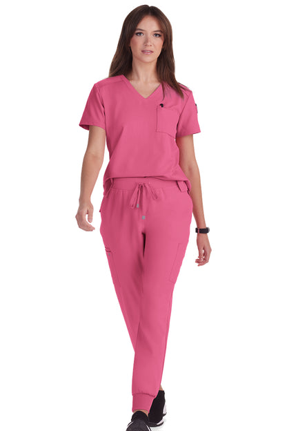 Women's Koi Cureology Aura C100 tuck in scrub top in carnation pink - moisture-wicking v-neck medical scrub with functional pockets for nurses and healthcare professionals.
