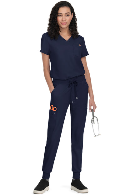 Women's Koi Cureology Aura C100 navy blue tuck in scrub top for nurses and healthcare professionals. Moisture wicking v-neck medical scrub with functional pockets.