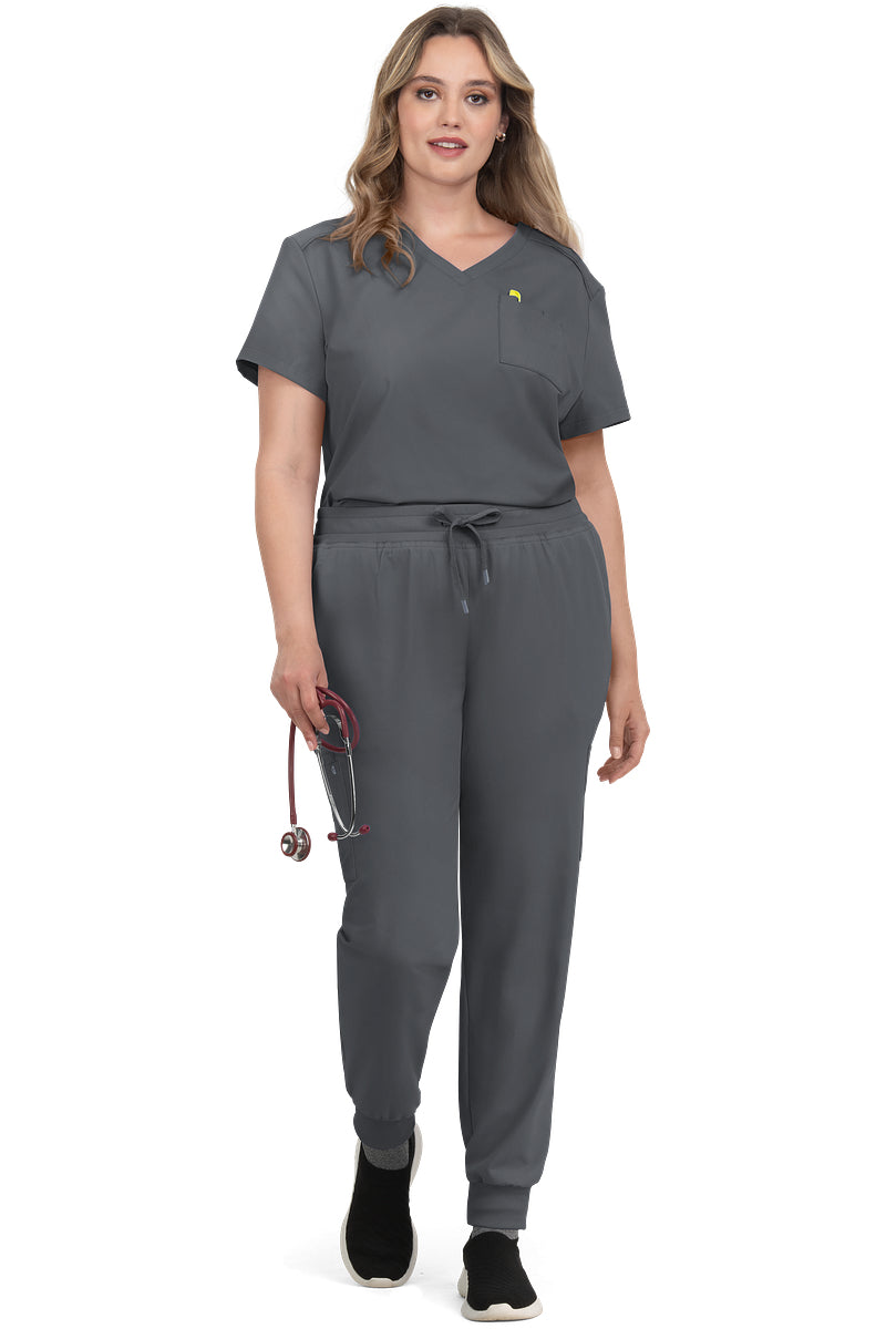 Women's Koi Cureology Aura C100 moisture wicking v-neck tuck in scrub top shown in pewter grey - medical scrub with functional pockets for nurses and healthcare professionals.