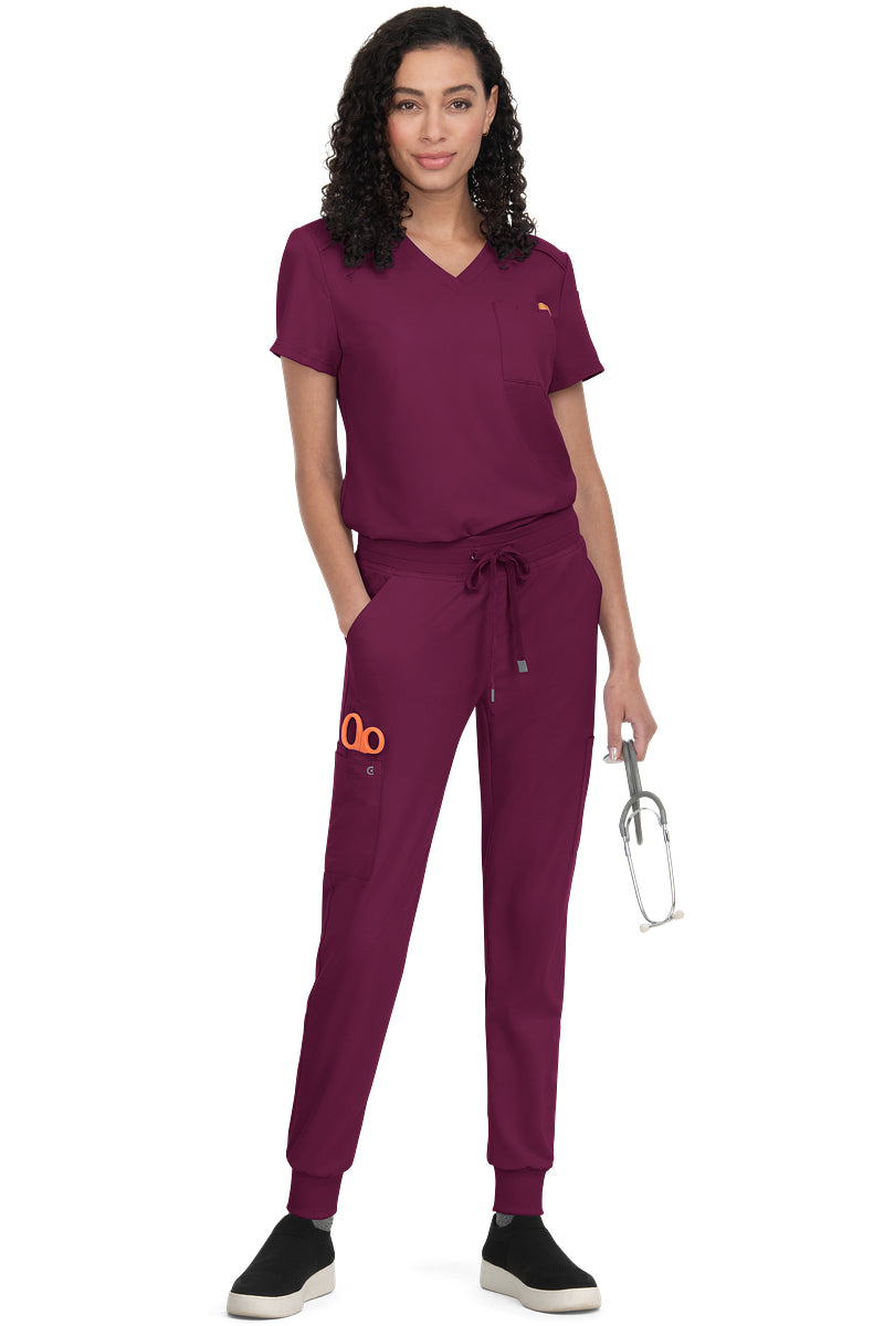 Women's Koi Cureology Aura C100 tuck in scrub top in wine red - moisture-wicking v-neck medical scrub with functional pockets for nurses and healthcare professionals.