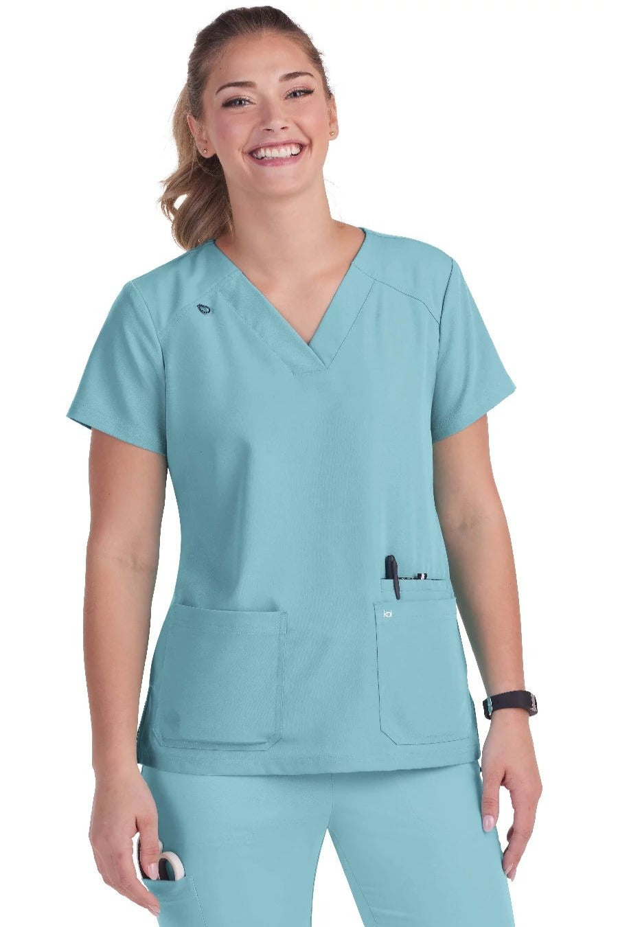 Koi Next Gen Hustle and Heart scrub top 1019 in Sea Glass - comfortable medical scrub with 3 pockets and badge loop for nursing professionals.
